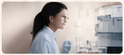 A researcher in a lab coat near laboratory equipment